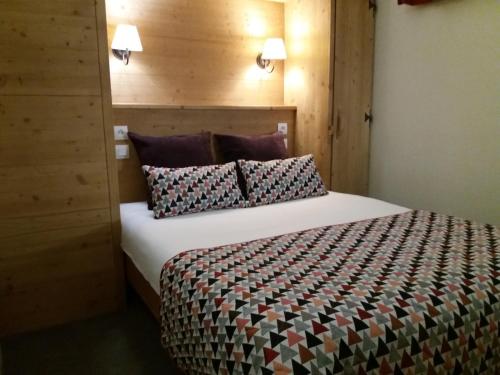 a bedroom with a large bed with a wooden headboard at Résidence Le Chamois d'Or in Val Thorens