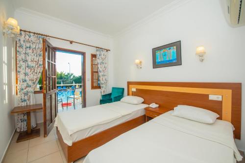 a hotel room with two beds and a balcony at White Hotel in Oludeniz