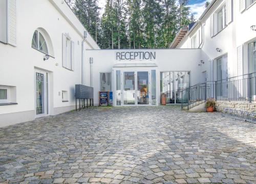 a white building with a sign that reads rejection at Lipno Club in Frymburk