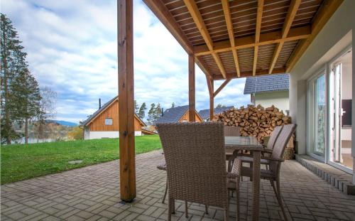 a patio with a table and chairs and a pile of wood at Lipno Club in Frymburk