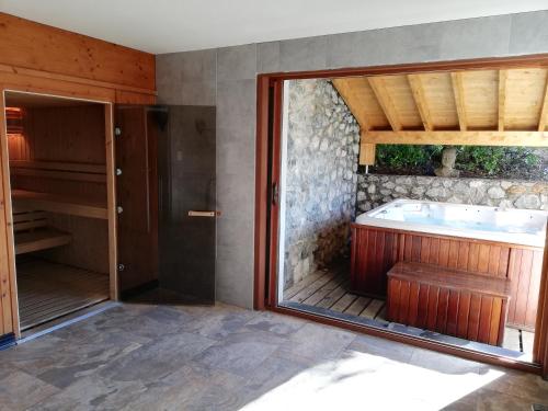 baño con bañera y ventana grande en Les GITES DE CAMPARAN - gîte "le GRAND CHALET AVEC SPA ET SAUNA", en Camparan