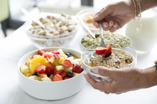 a group of people eating a bowl of fruit and cereal at Johannesbad Hotel Füssinger Hof in Bad Füssing