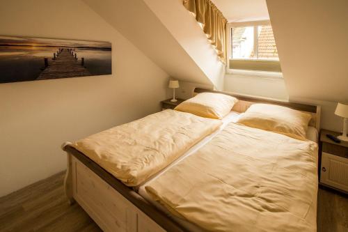 ein großes Bett in einem Zimmer mit Fenster in der Unterkunft Frau Clara Haus - Ecke 3 in Eckernförde