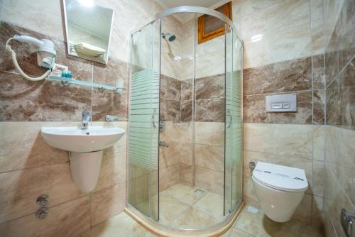 a bathroom with a shower and a sink and a toilet at White Hotel in Oludeniz