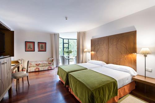 a bedroom with a large bed and a living room at Parador de Limpias in Limpias