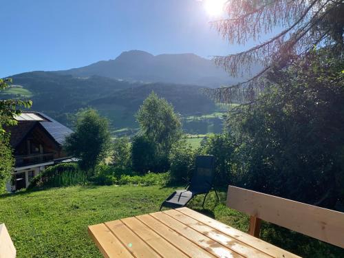 a table and a chair in a field with a mountain at Apartment HaNiLe in Sarntal