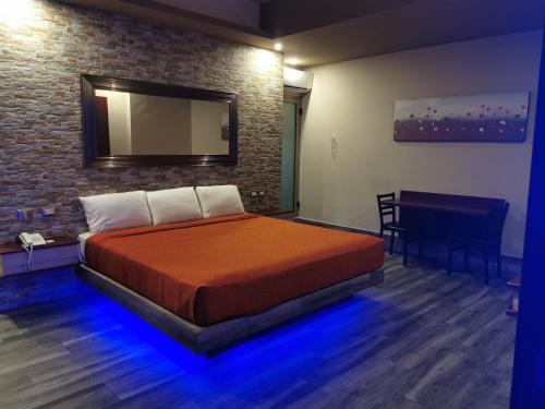 1 dormitorio con cama, mesa y espejo en Hotel Plaza Arteaga en Monterrey