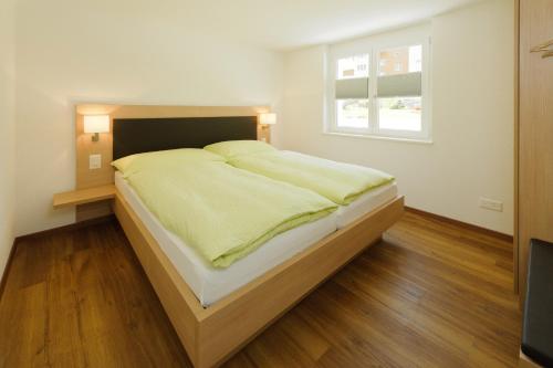 a large bed in a bedroom with a window at Andolla in Saas-Almagell