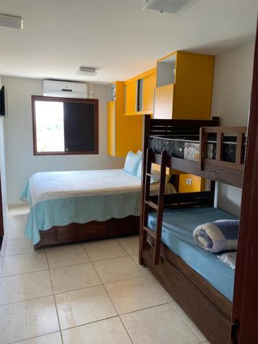 a bedroom with two bunk beds and a flat screen tv at flat em serra negra - bezerros in Bezerros