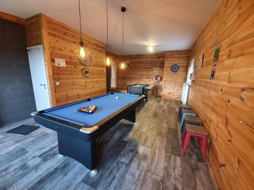 a pool table in a room with wooden walls at Gîte Le Rivage in Stavelot