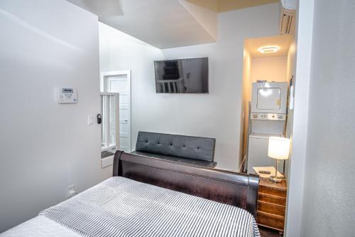 1 dormitorio pequeño con 1 cama y TV en Guest House with Loft Near Downtown en San Antonio