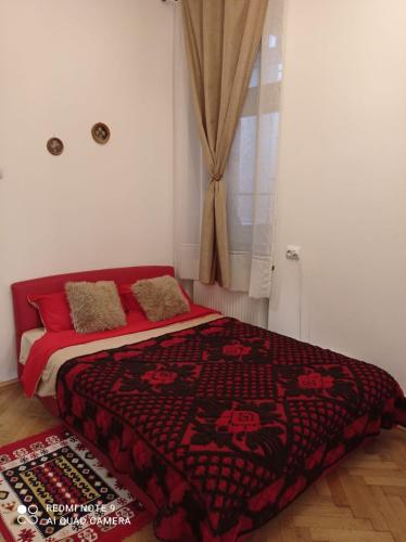 a bedroom with a bed with a red blanket and a window at Central View Piata Sfatului 7- Panoramic Apartment in Braşov