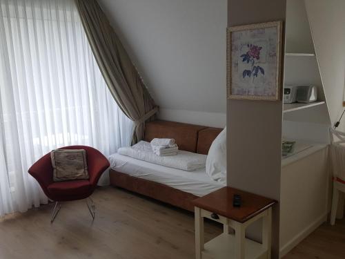 een kleine slaapkamer met een bed en een stoel bij Sylter-Besserburg-App-9 in Westerland