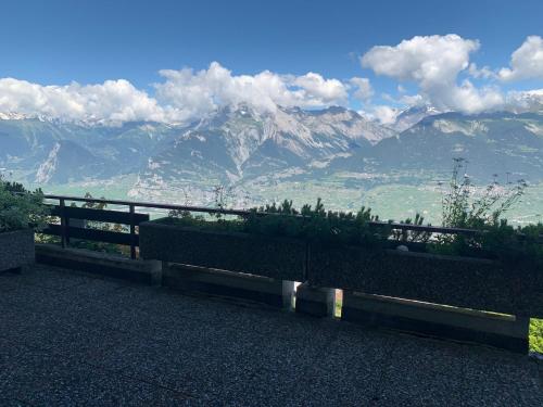 a bench with a view of the mountains at Studios Bellevue 1 et 2, ski lift 150m in Veysonnaz