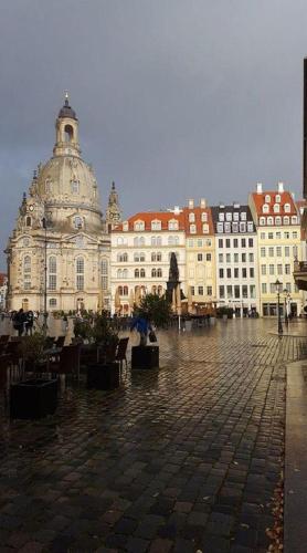 een groep gebouwen met tafels en stoelen op een binnenplaats bij Ferienwohnung-Dresden-Sued in Dresden