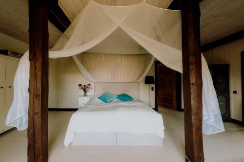a bedroom with a large bed with a canopy at Landhaus Kurzenmoor - Tenne (410 qm) in Seester