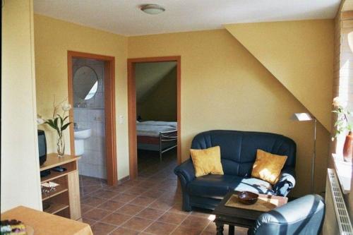 un soggiorno con divano blu e una camera da letto di Augustenberg-Wohnung-2 a Landkirchen