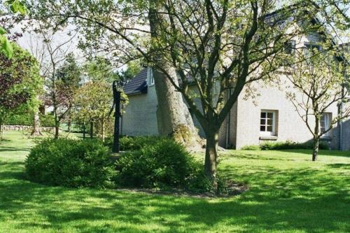 una casa bianca con un albero in un cortile di Augustenberg-Wohnung-2 a Landkirchen