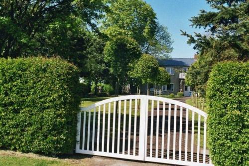 a white gate in front of some bushes at Augustenberg-Wohnung-2 in Landkirchen