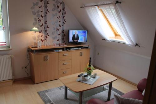 ein Wohnzimmer mit einem Tisch und einem TV in der Unterkunft Wohnung 2 in Oevenum