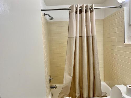 Scottish Inns and Suites- Bordentown, NJ في بوردينتاون: حمام مع ستارة دش ومرحاض