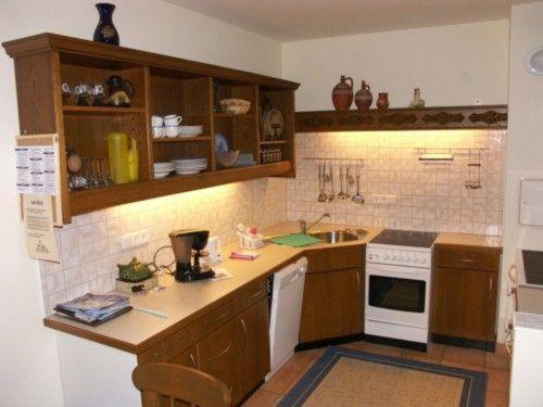 a kitchen with wooden cabinets and a white appliance at Ferien-am-Bauernhof-Wohnung-3 in Rangersdorf