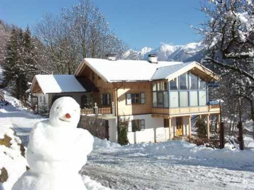 a snow man standing in front of a house at Ferien-am-Bauernhof-Wohnung-3 in Rangersdorf