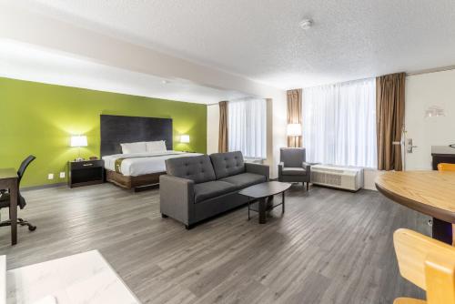 a hotel room with a bed and a couch and a table at Quality Inn & Suites Vandalia near I-70 and Hwy 51 in Vandalia