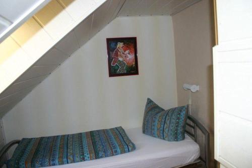Una cama en una habitación con una escalera con una foto en la pared en Haus-Kummeleck-Wohnung-2, en Bad Lauterberg