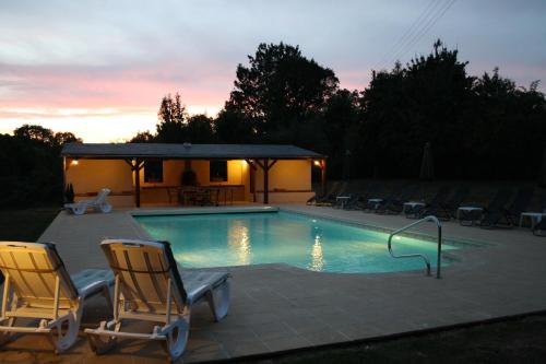 una piscina con 2 sillas y un cenador en Wisteria Gite, en Asnières-sur-Vègre