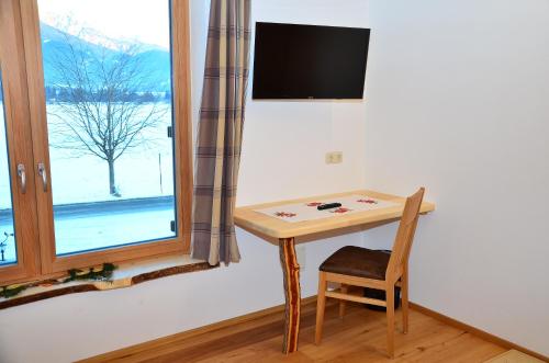 a small table and a chair next to a window at Kleintödlinggut in Leogang