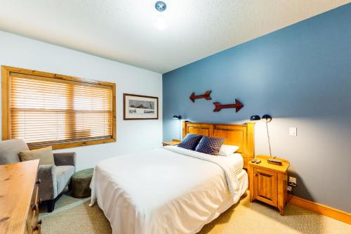 a bedroom with a white bed and a blue wall at Condo 123 at Snowbridge in Blue Mountains