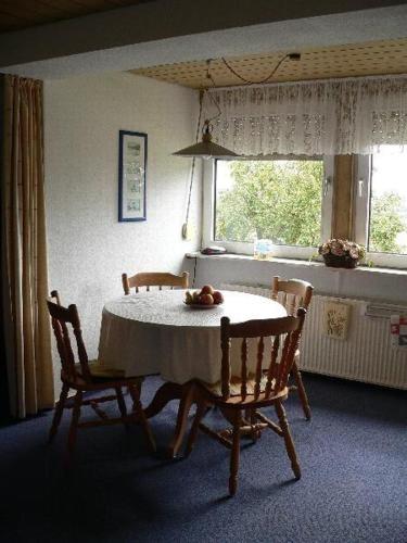 a table and chairs in a room with a window at Apartment-1 in Schönhagen