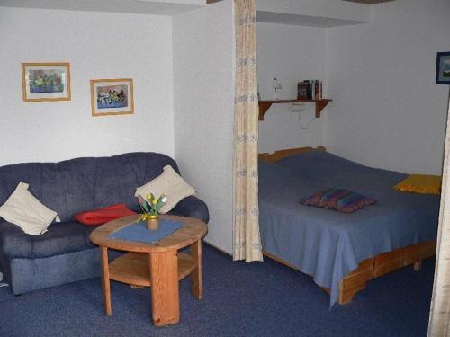 a living room with a couch and a bed at Apartment-1 in Schönhagen