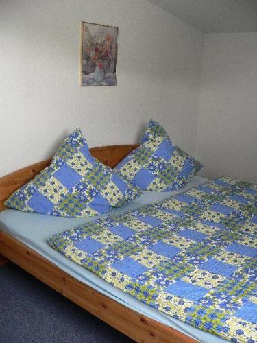 a bed with blue and yellow sheets and pillows at Apartment-1 in Schönhagen