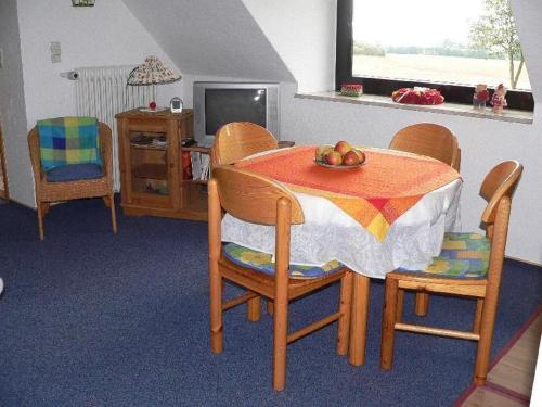 a dining room with a table with a bowl of fruit on it at Apartment-2 in Schönhagen