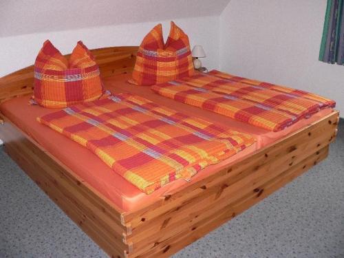 a wooden bed with two pillows on top of it at Apartment-2 in Schönhagen