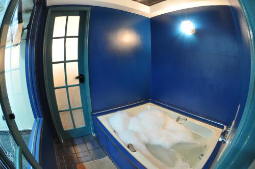 a blue bathroom with a tub in a room at Hotel Fênix (Adult Only) in Rio de Janeiro