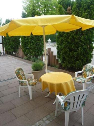 フライブルク・イム・ブライスガウにあるFerienwohnungen-Roder-Ferienwohnung-IIの黄色の傘下の椅子