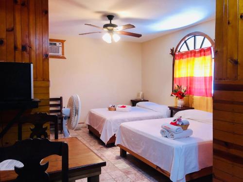 a room with two beds and a ceiling fan at Hotel Paraíso del Pescador by Rotamundos in San Agustinillo