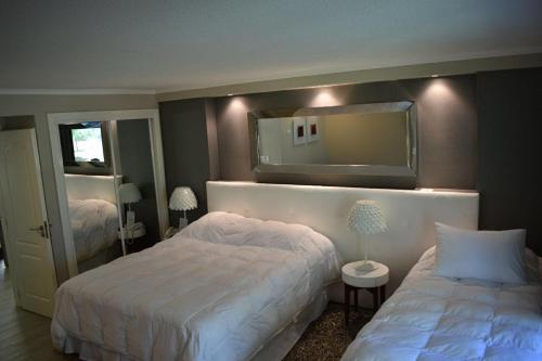 1 dormitorio con 2 camas y espejo en Forest Lagoon Apartamento 6 en Punta del Este