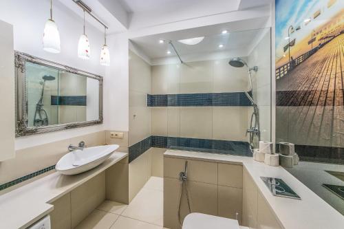 ein Bad mit einem Waschbecken und einer Dusche in der Unterkunft Apartamenty House Managers - Monte 49 in Sopot