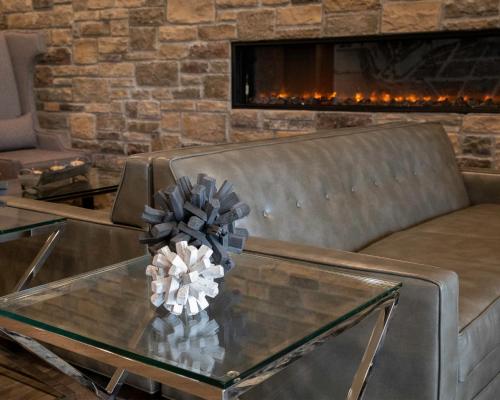 a living room with a couch and a glass table at Cobblestone Hotel & Suites - Two Rivers in Two Rivers