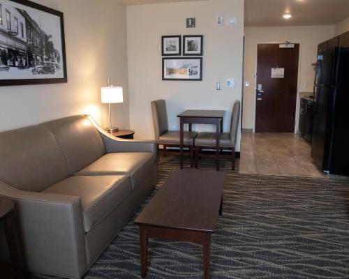 a living room with a couch and a table at Cobblestone Hotel & Suites - Two Rivers in Two Rivers