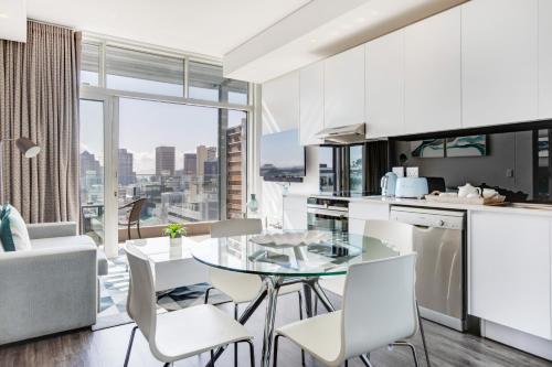 a kitchen and dining room with a view of the city at Backup-Powered Trendy City Sanctuary in Cape Town