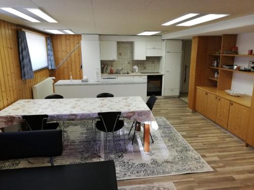 uma cozinha com mesa e cadeiras num quarto em Suretta2 em Splügen