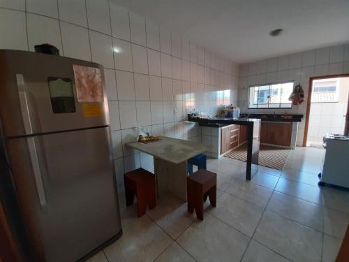 a kitchen with a refrigerator and a table in it at Casamatta Hostel - Unidade Aventura in Pirenópolis