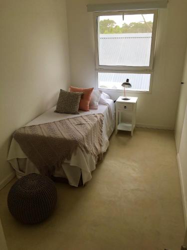 a small bedroom with a bed and a window at Best Vila in José Ignacio - Pinar del Faro with maid! in José Ignacio
