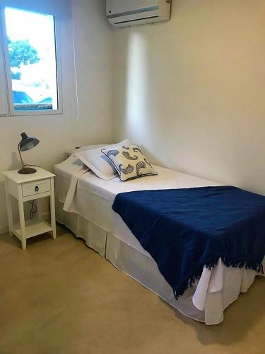 a bedroom with a bed and a night stand with a lamp at Best Vila in José Ignacio - Pinar del Faro with maid! in José Ignacio