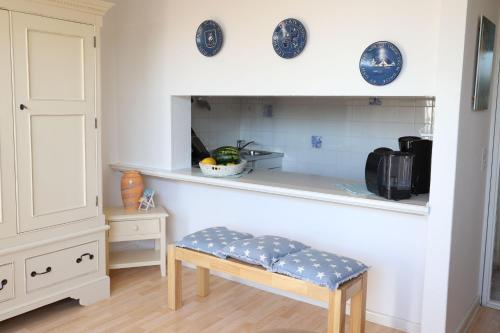 uma cozinha com um banco e um balcão com placas azuis em Ferienwohnung-Kolberger em Westerland